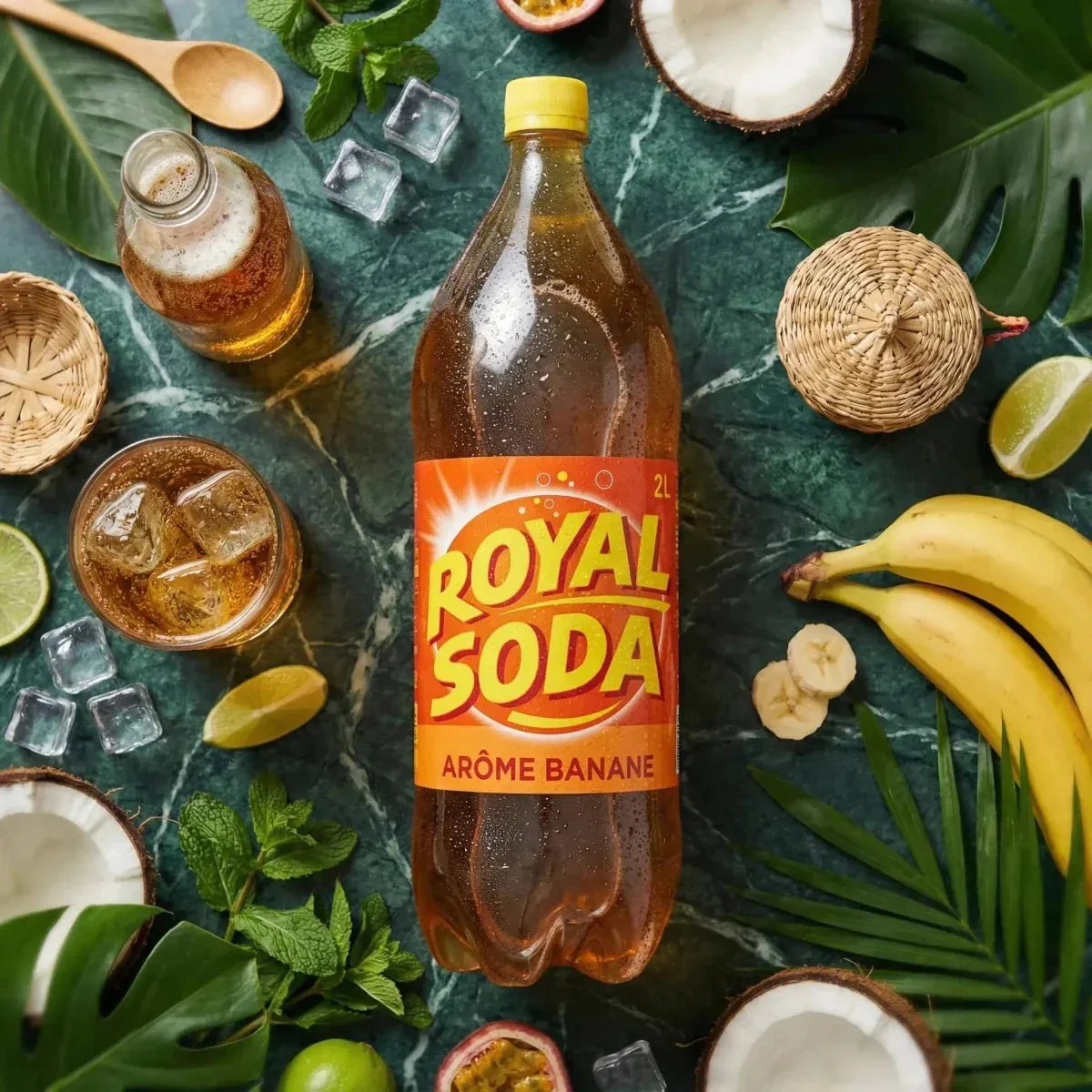 Botella de refresco ROYAL SODA sabor plátano 2L, rodeada de frutas exóticas y hojas tropicales.