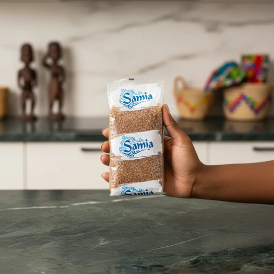 Main tenant un paquet de boulgour brun gros SAMIA dans une cuisine moderne, produit d'épicerie salée à base de blé dur complet.