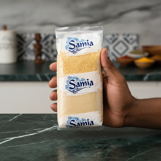 Main tenant un paquet de boulgour gros SAMIA dans une cuisine moderne. Produit d'épicerie salée, facile à préparer et polyvalent.