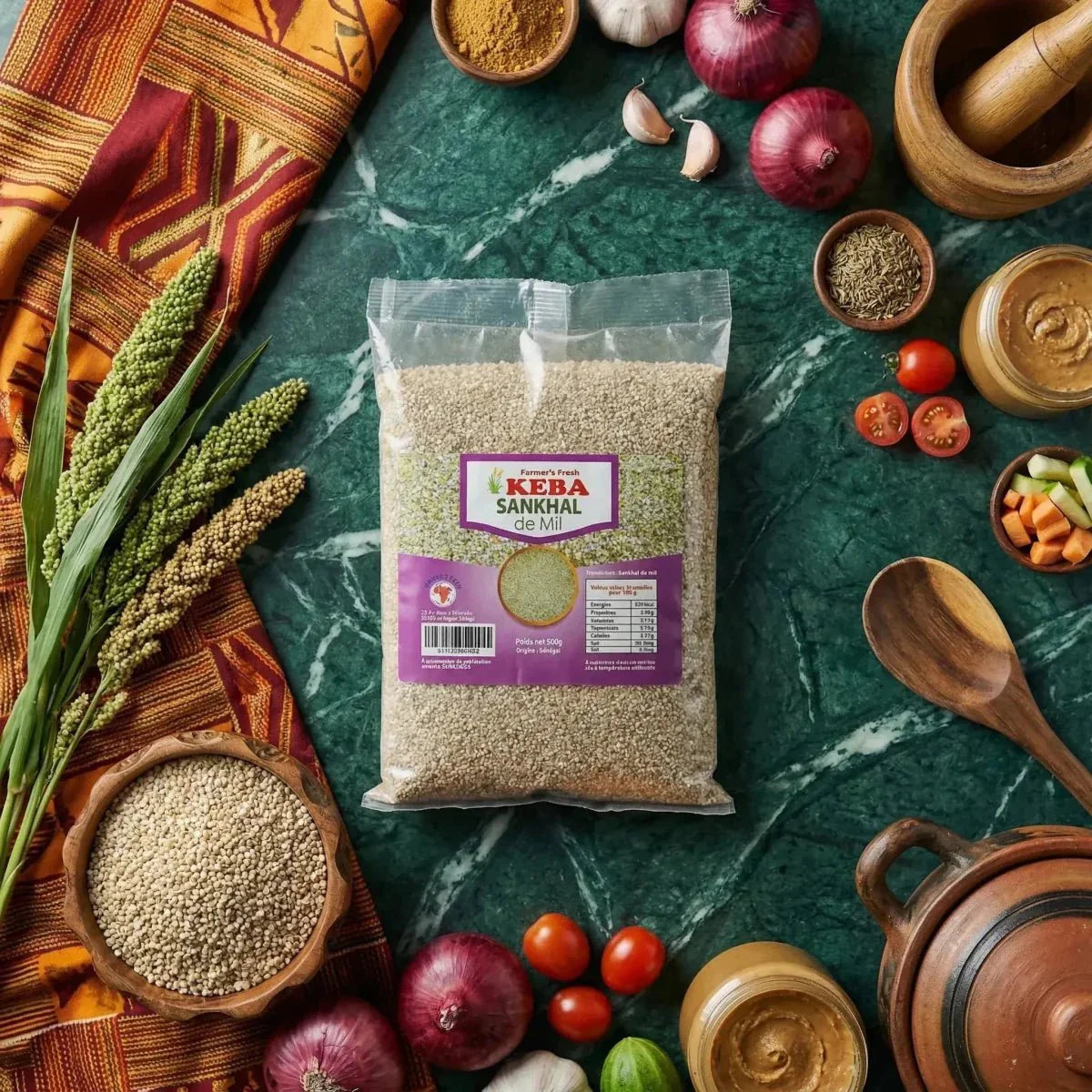 Sankhal de Mil KEBA (500g) auf einem Tisch mit Gewürzen, Gemüse und Küchenutensilien.