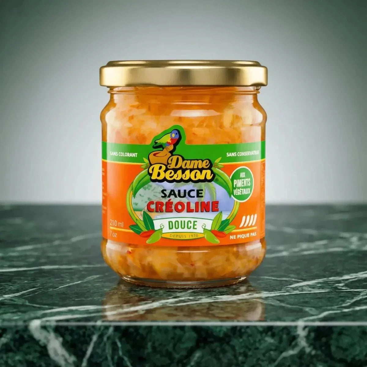 Barattolo di salsa creola dolce Dame Besson su un piano di lavoro in marmo. Etichetta arancione.