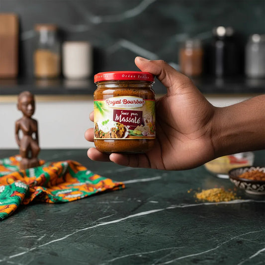 Main tenant un pot de sauce massalé ROYAL BOURBON, produit d’épicerie salée aux saveurs créoles, parfait pour relever vos plats.