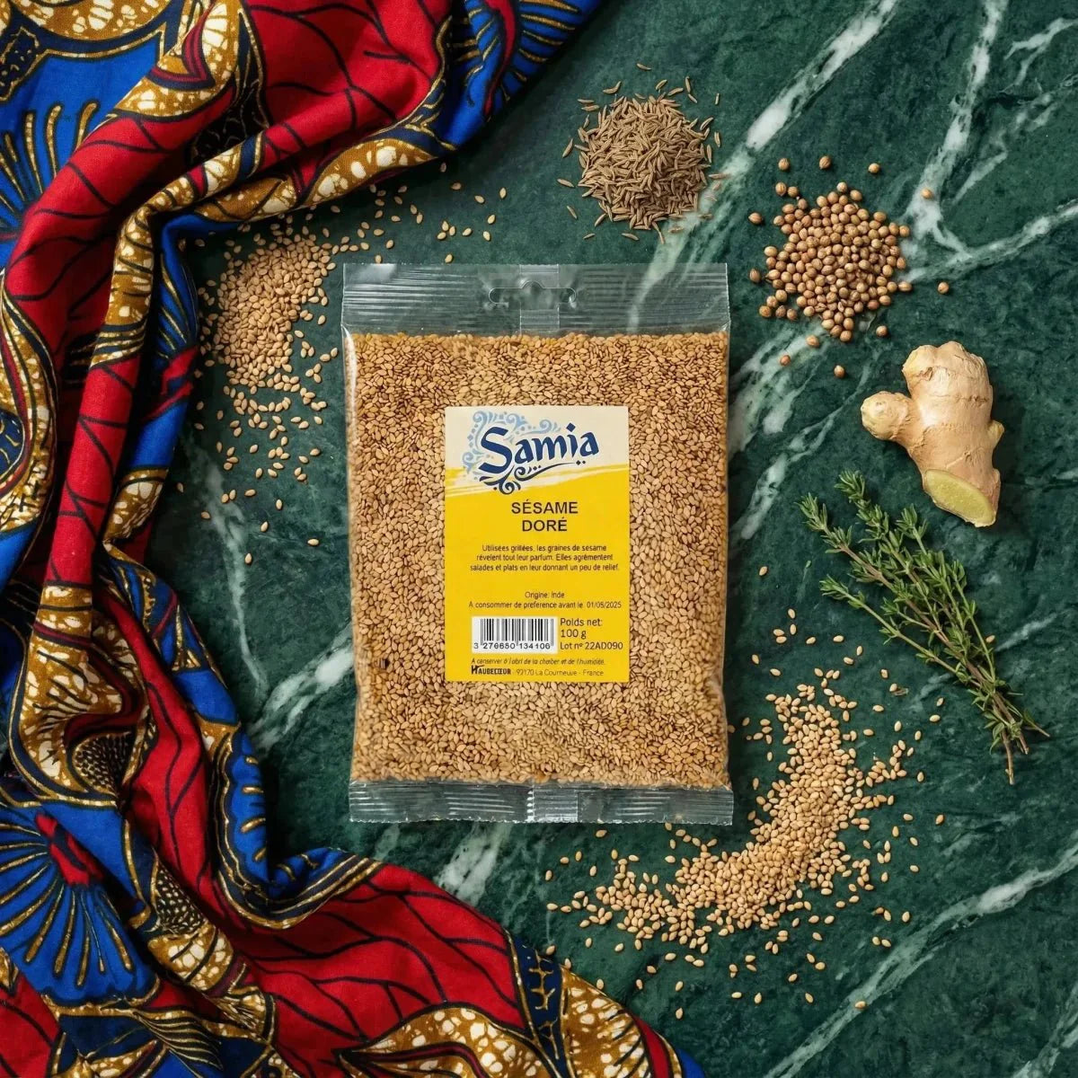 Sachet de sésame doré SAMIA sur fond vert marbré, entouré d'épices, de gingembre, de thym.