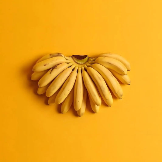Régime de bananes fraîches sur fond jaune, illustrant l’ingrédient principal du soda goût banane ROYAL SODA. Parfait pour évoquer la douceur naturelle.
