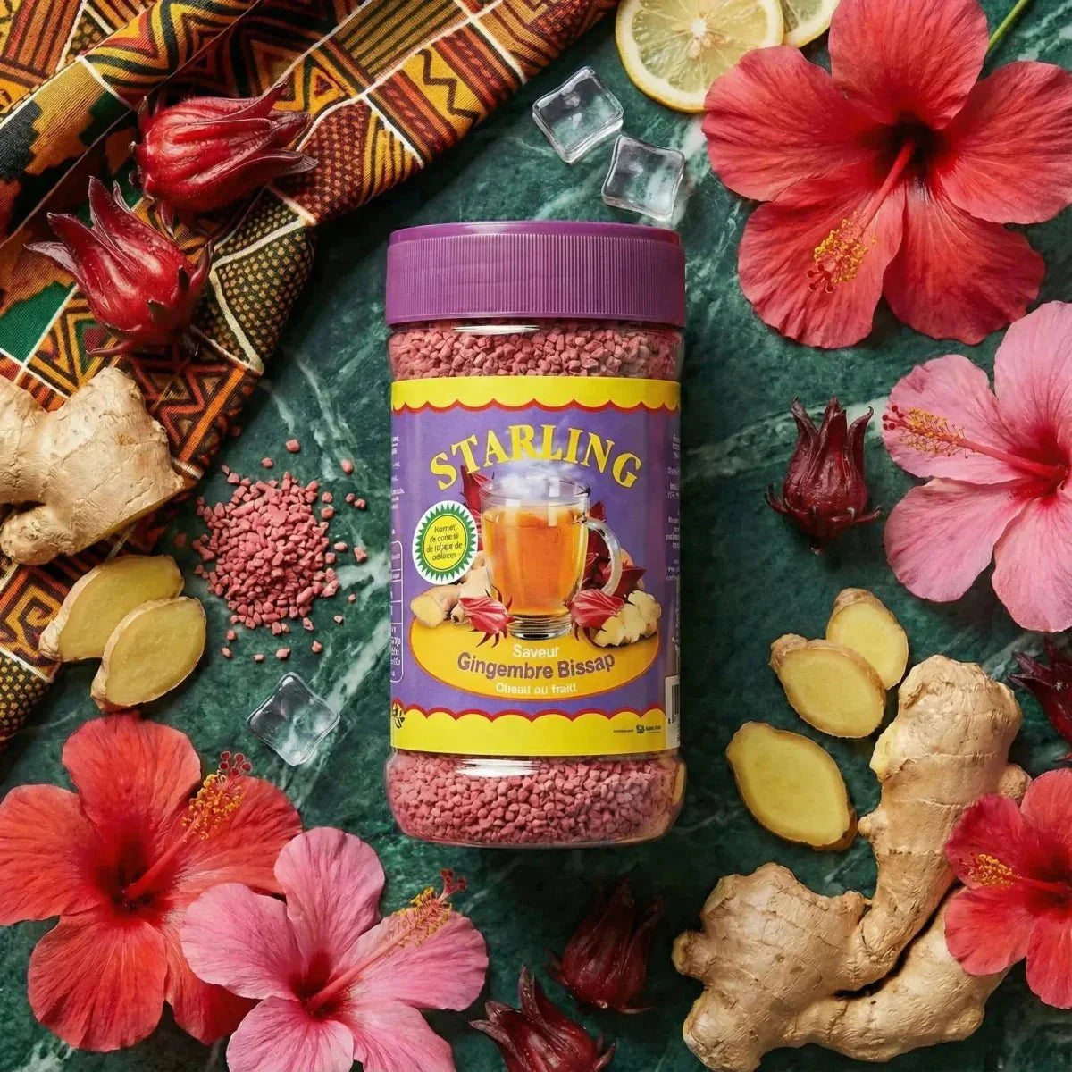 Starling Ingwer-Bissap-Tee präsentiert mit frischem Ingwer, Hibiskusblüten, Eis und Zitrone.