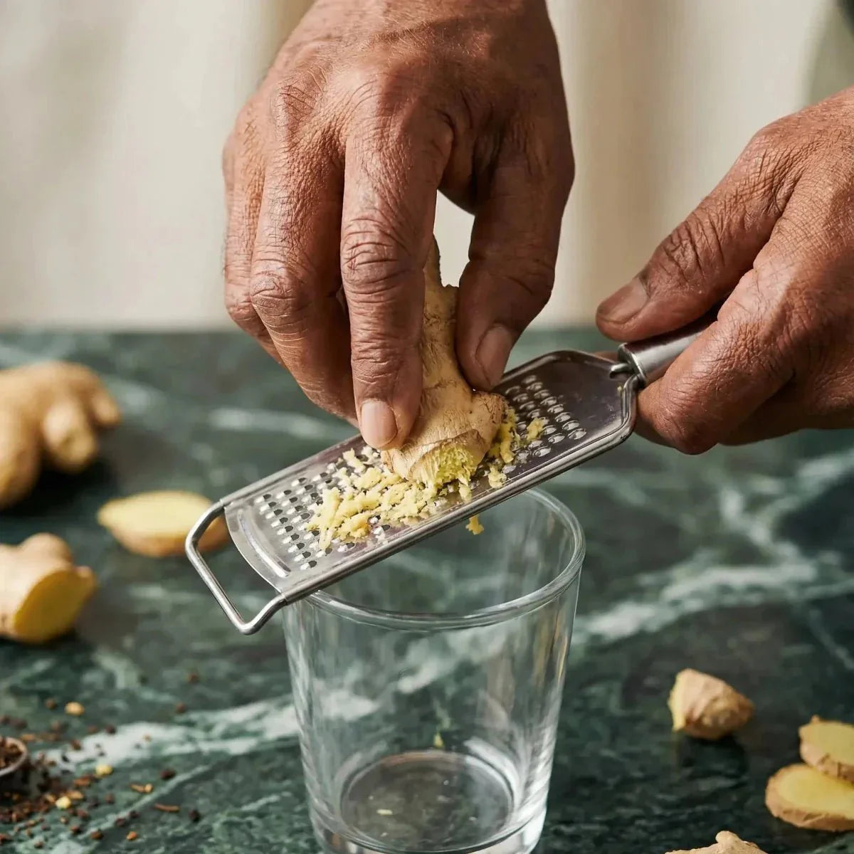 Instant STARLING ginger tea, grated in a clear glass on a counter.