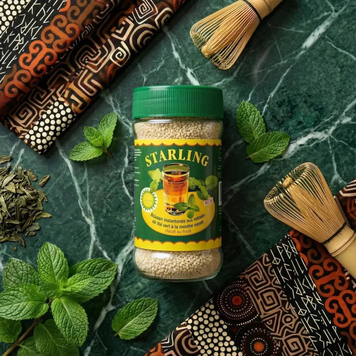 Nanah STARLING muntthee in een gemarmerde pot met Afrikaanse versieringen, verse munt.