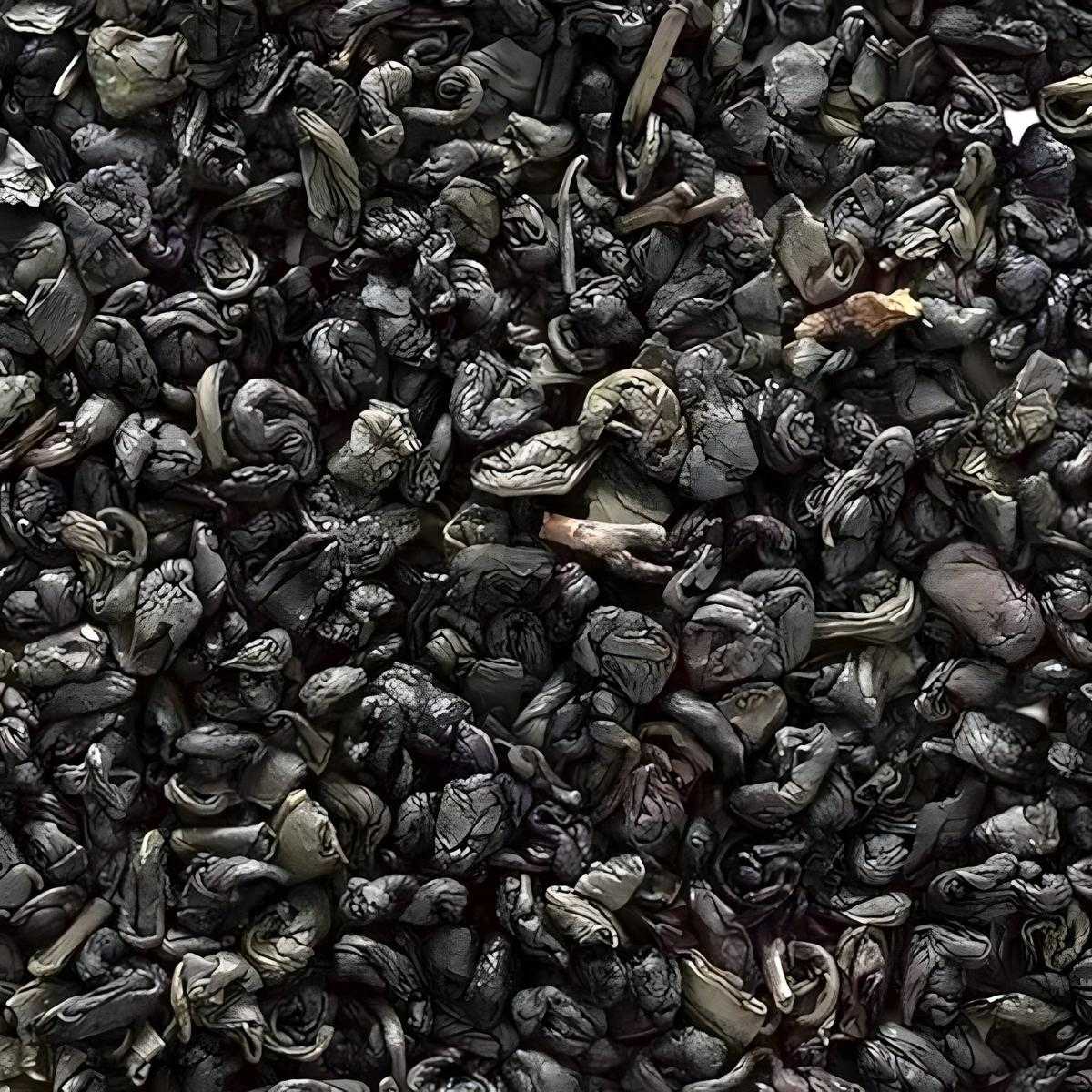 Gros plan sur les feuilles roulées du thé vert gunpowder superextra 555, thé en vrac à l’arôme végétal, idéal pour infusion traditionnelle.