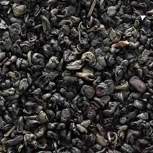 Gros plan sur les feuilles roulées du thé vert gunpowder superextra 555, thé en vrac à l’arôme végétal, idéal pour infusion traditionnelle.
