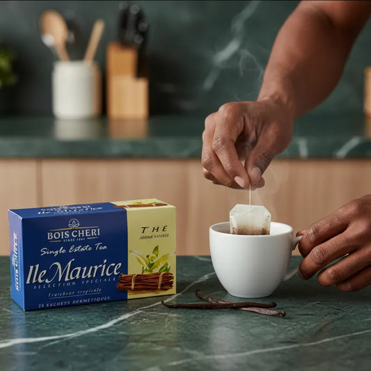 Infusion d’un sachet de thé vanille Bois Chéri dans une tasse, avec boîte visible sur un plan de travail de cuisine moderne.