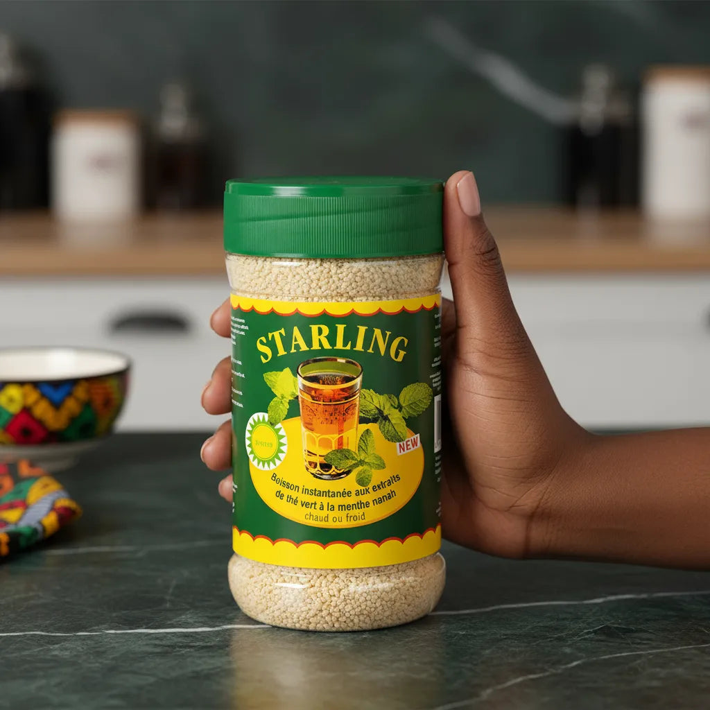 Main tenant un pot de Thé Menthe Nanah STARLING, boisson instantanée au thé vert et menthe nanah, parfaite pour une consommation chaude ou froide.