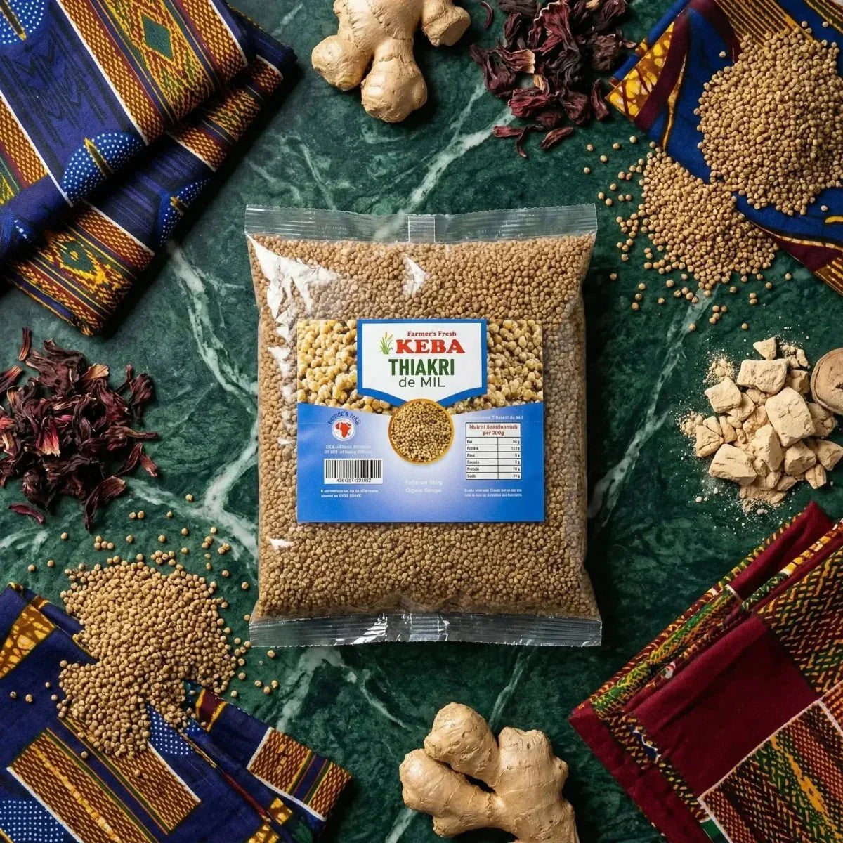 Thiakri de mil en sachet de KEBA, entouré de gingembre, d'hibiscus séché et de tissus traditionnels.