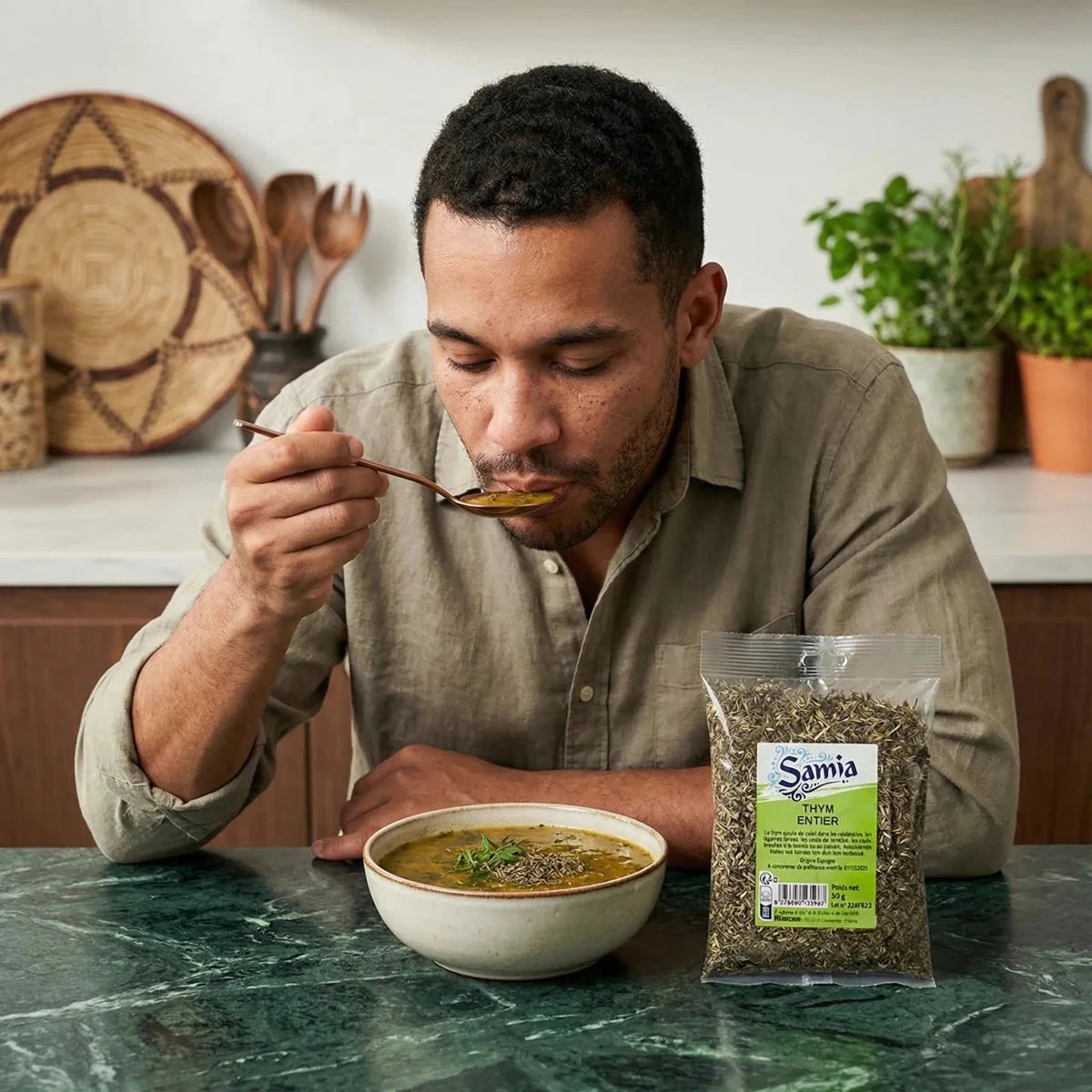 Thym entier par SAMIA, en sachet transparent, présenté sur une table en marbre avec une soupe.