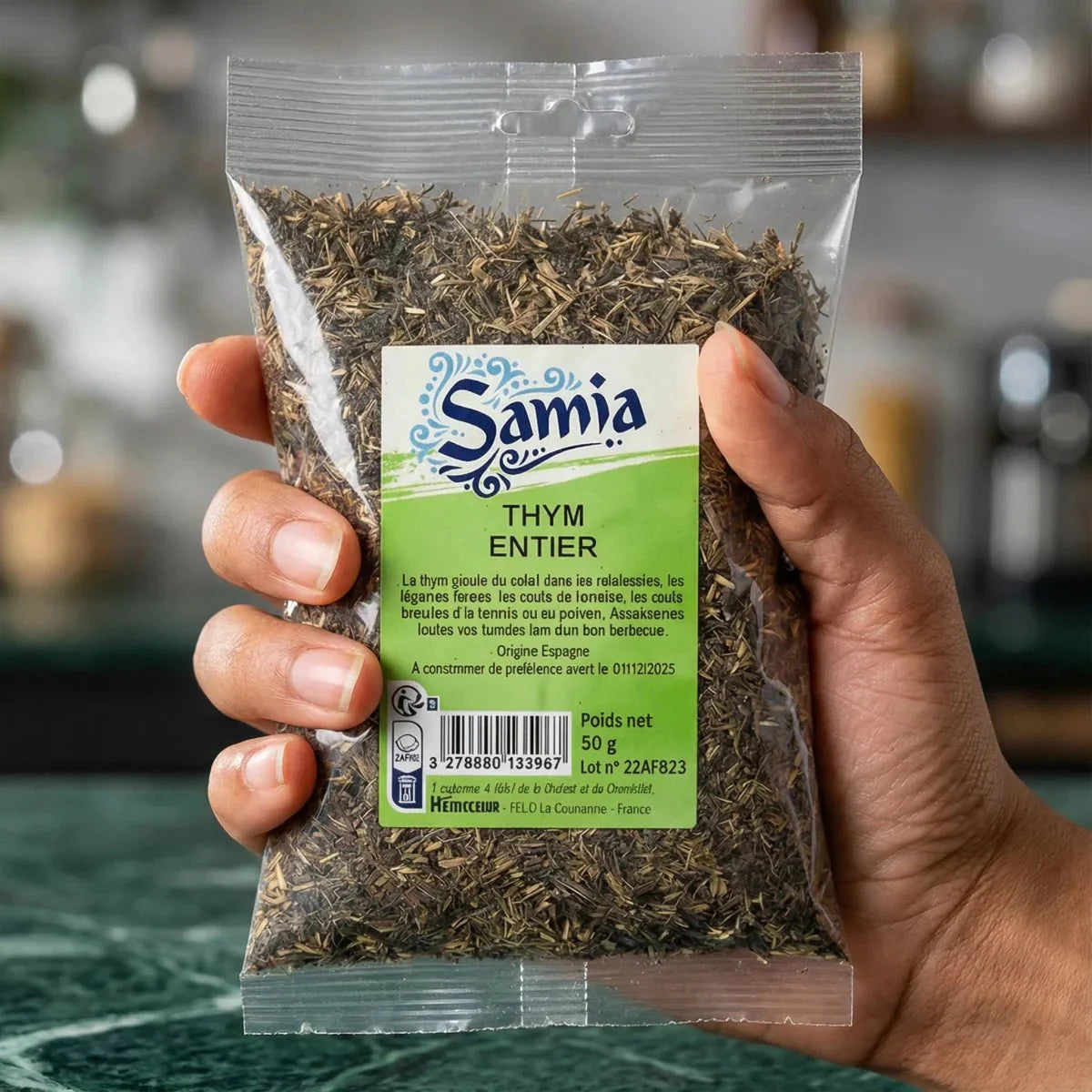 Thym entier séché par SAMIA, en sachet transparent tenu dans une main.

