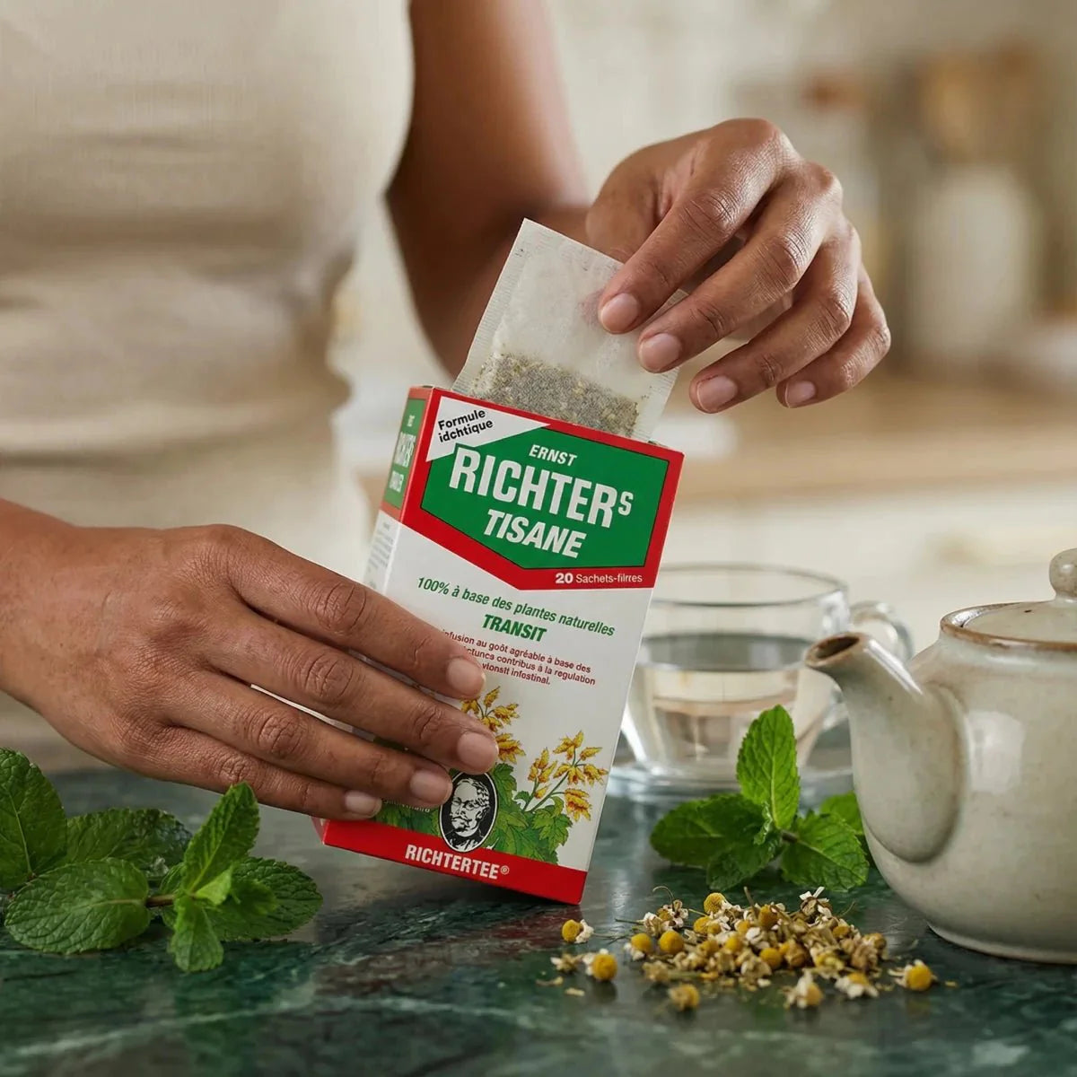 Transit-kruidenthee van ERNST RICHTER'S bereid met een theepot, kopje en natuurlijke ingrediënten.