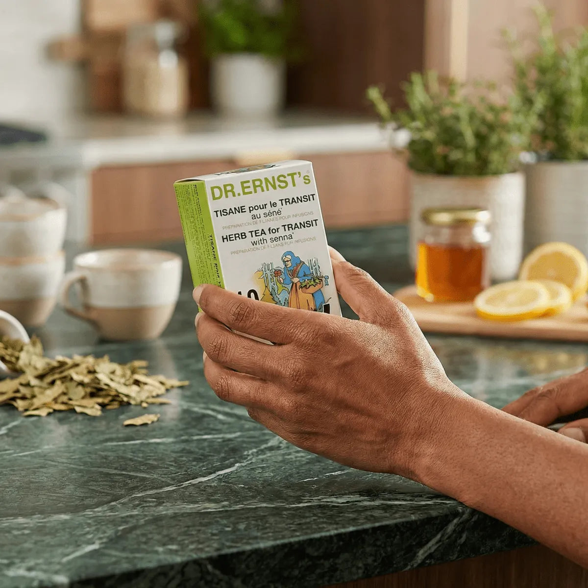 Thee voor de spijsvertering van DR ERNST'S, vastgehouden in één hand, met gedroogde bladeren.